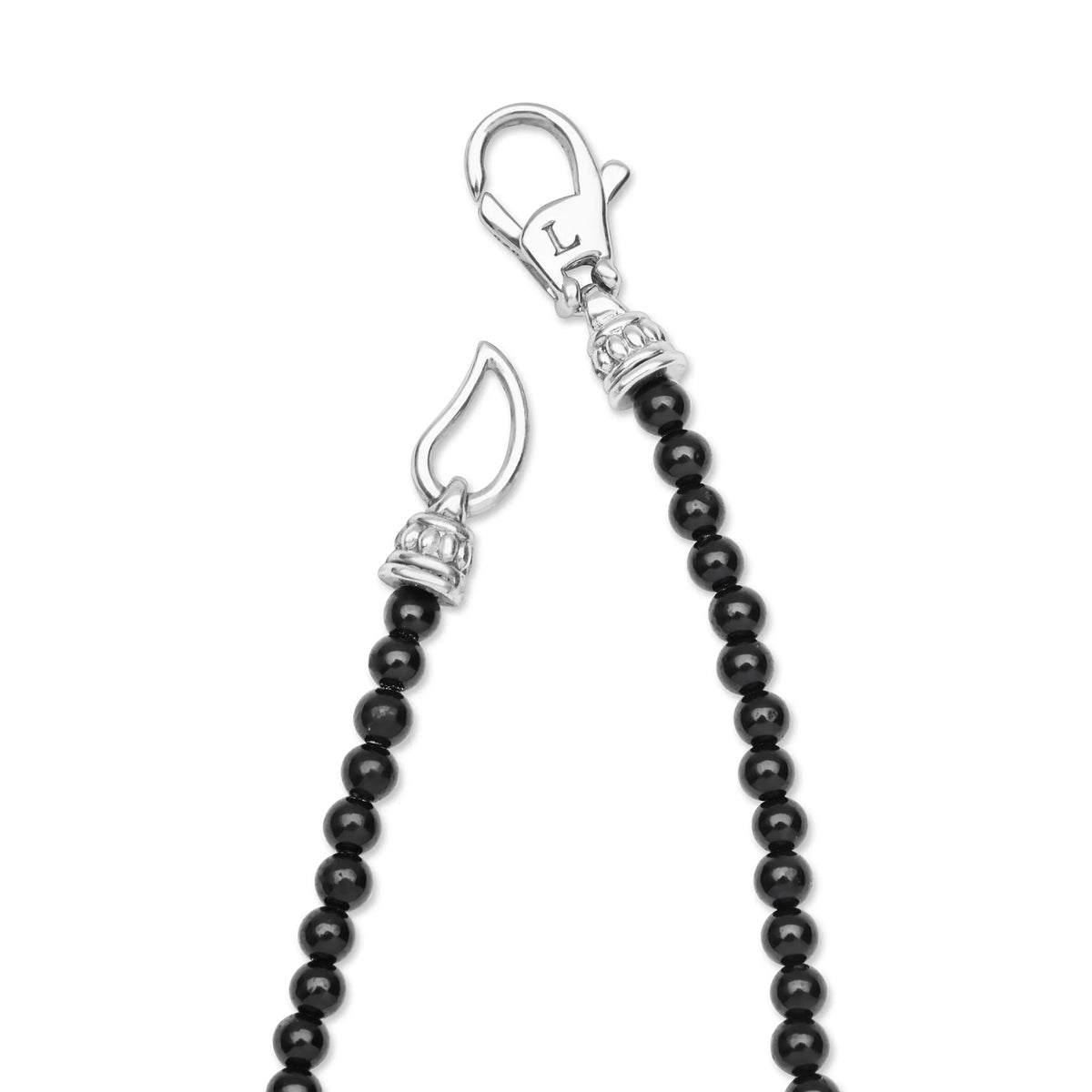 A close-up of a jewelry accessory featuring a black beaded strand with silver-toned clasp hardware, shown on a plain white background.
