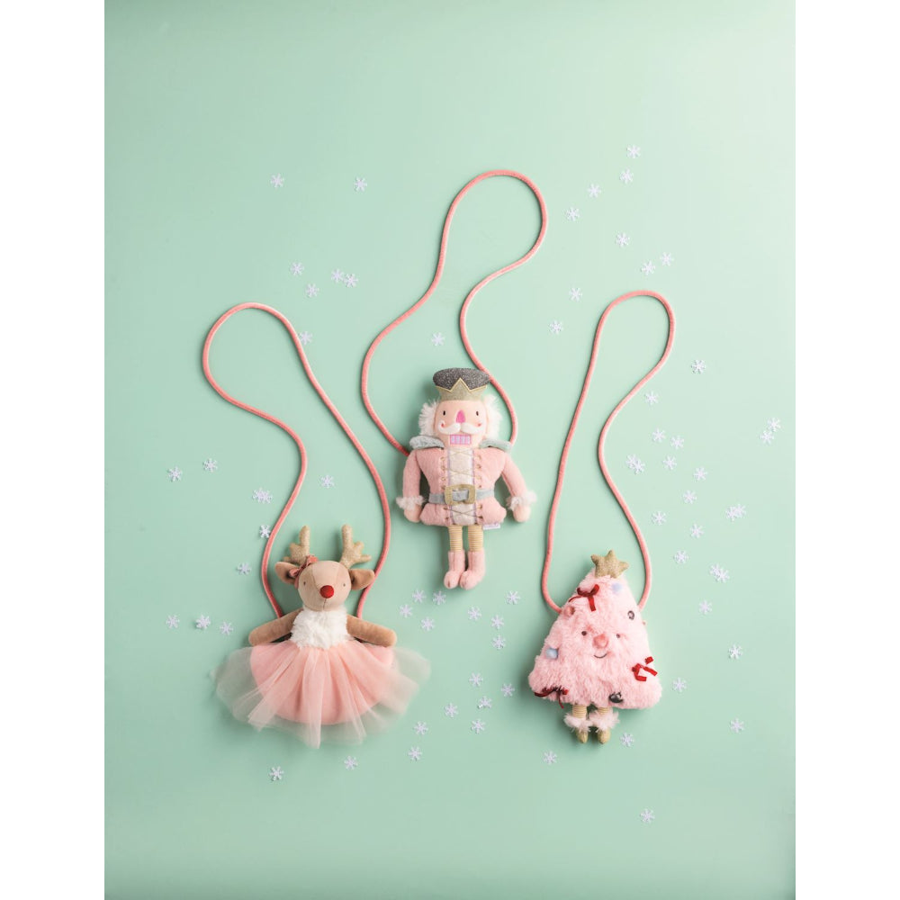 Three plush hoilday purses against a light green background.