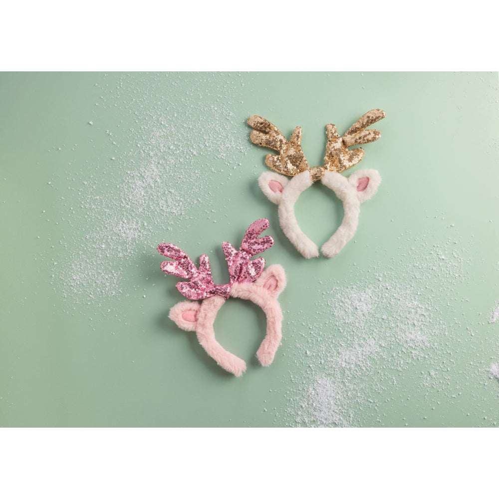 Two festive headbands with pink and gold antlers on a light green background.