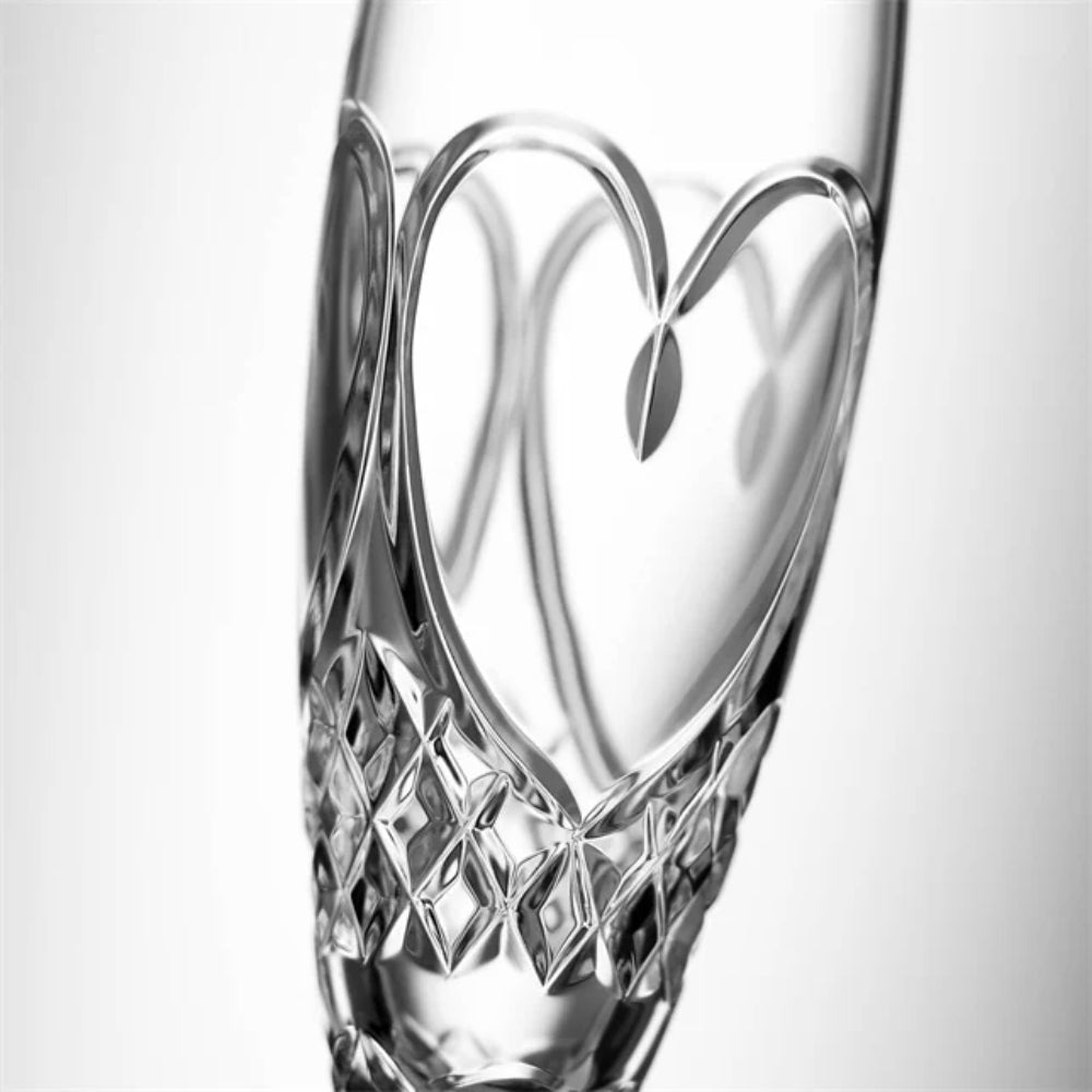 Crystal glass flute with heart design on a white background