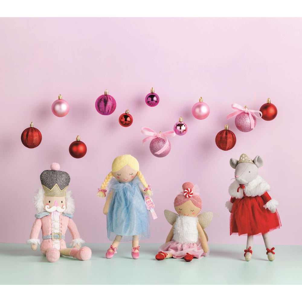 Holiday nutcracker ballet themed dolls with christmas ornaments on a pink background.