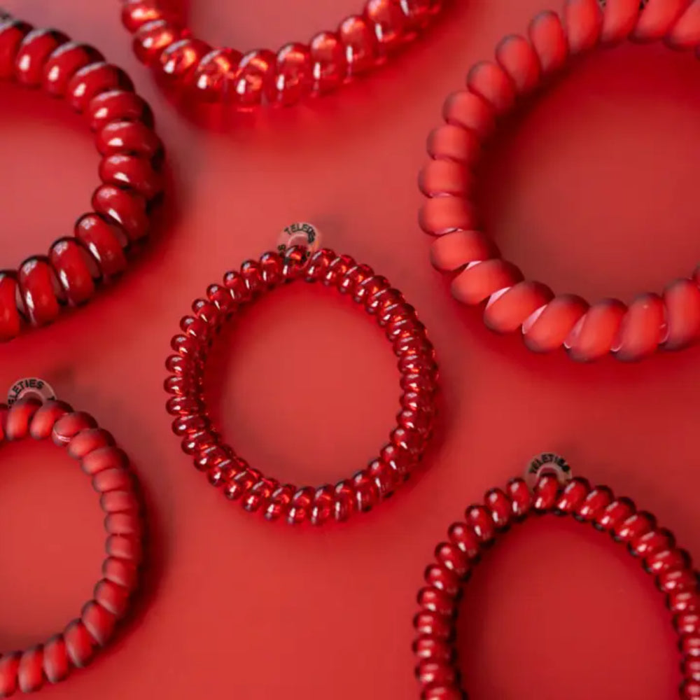 Red coil hair ties on a red background