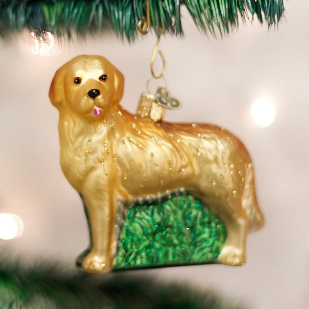 Glass ornament of a golden retriever dog on a Christmas tree.