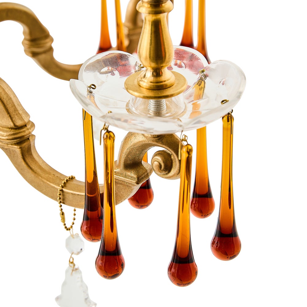 Decorative hanging ornament with gold and amber elements on a white background