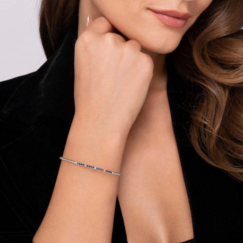Woman wearing a bracelet on her wrist with a plain background