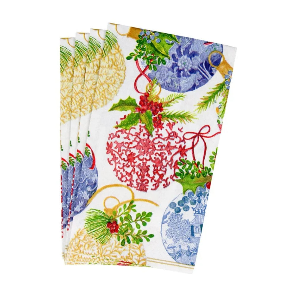 A stack of white kitchen tea towels featuring a colorful Christmas pattern with red and blue ornaments, green pine branches, holly leaves, and red berries, shown against a plain white background.
