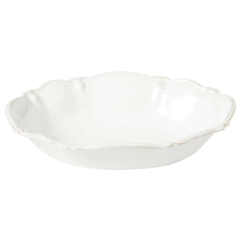 A white ceramic serving bowl with fluted edges and floral motifs from the Berry & Thread collection.