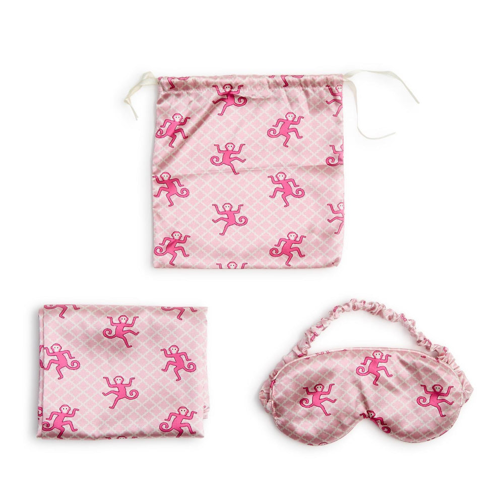 Pink drawstring bag, pouch, and eye mask with monkey pattern on a white background