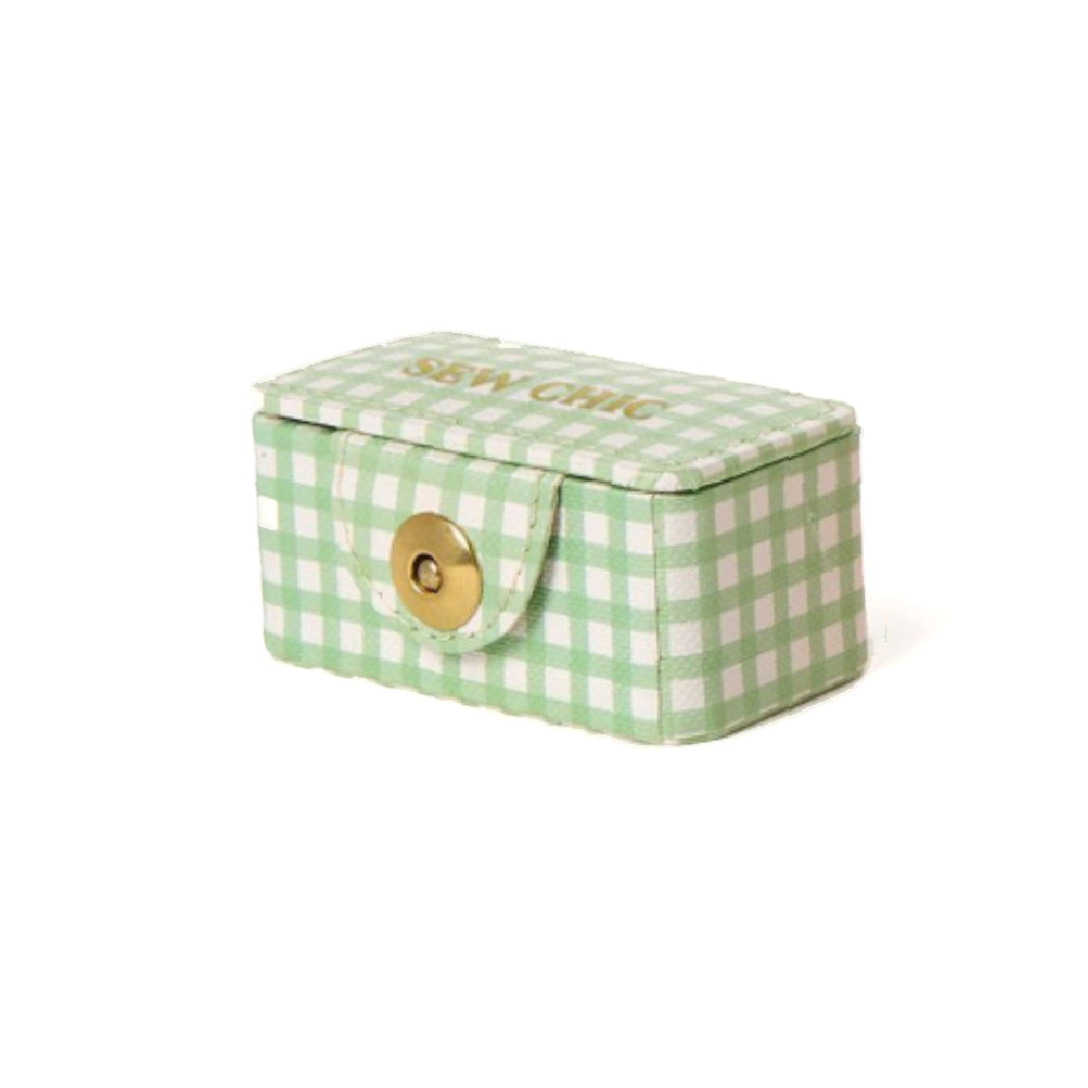 Green and white checkered sewing kit box with a gold button snap fastener on a white background.