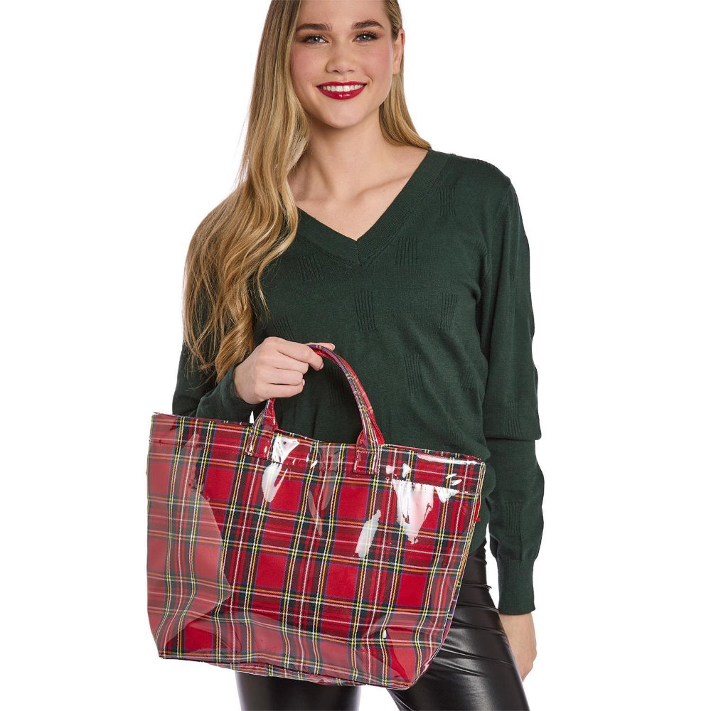 Woman holding a red tartan tote bag against a white background