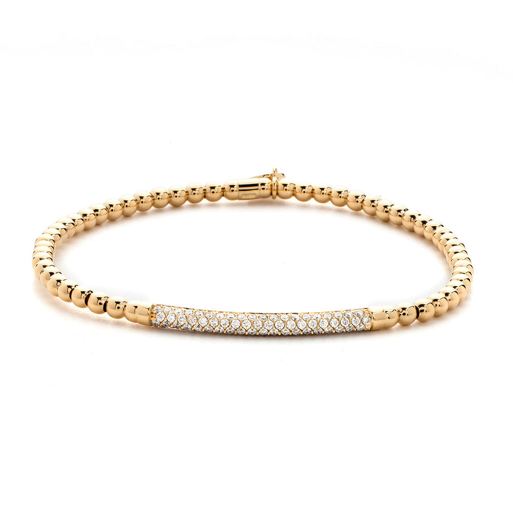 Gold bracelet with a bar clasp on a white background