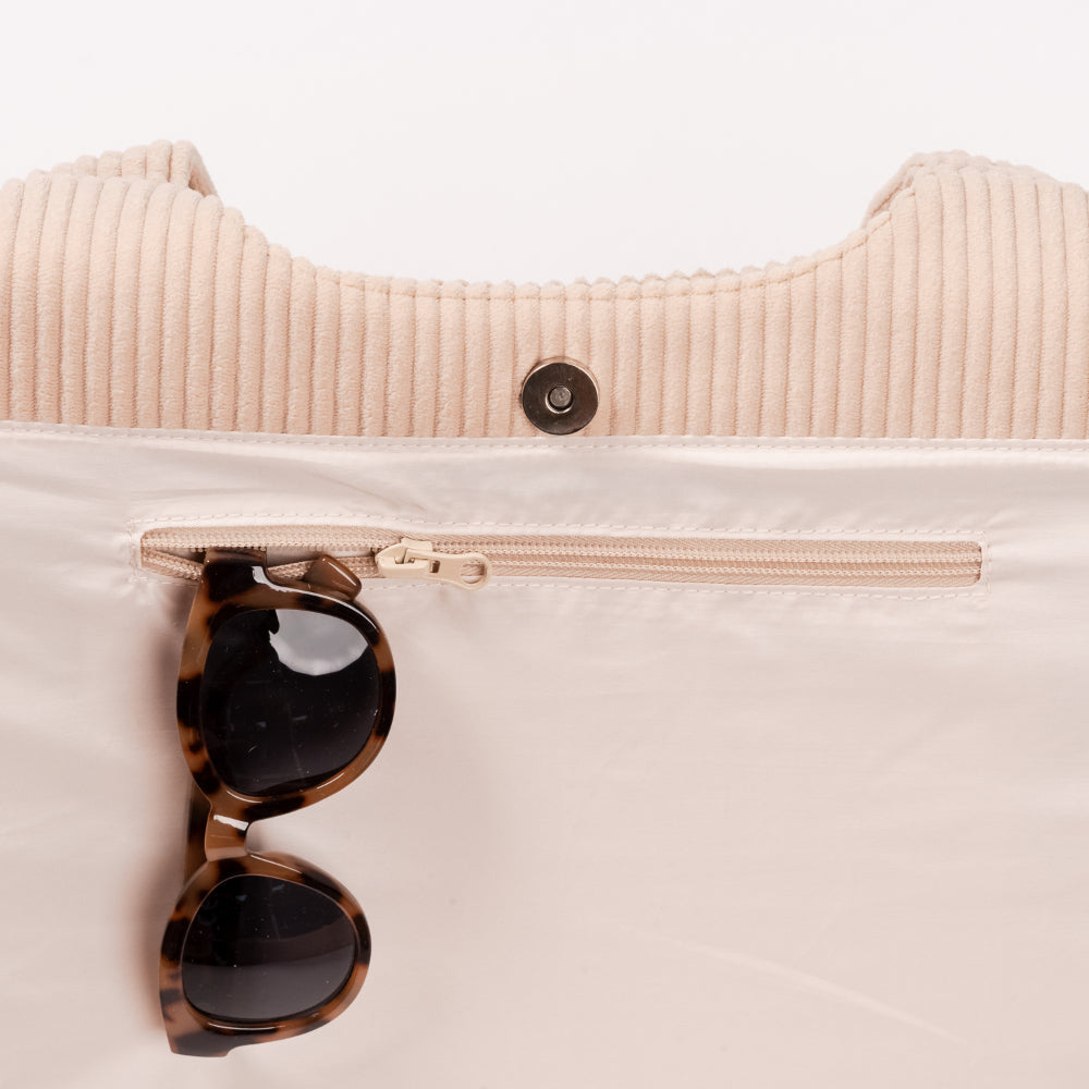 Sunglasses hanging from a beige pouch with a zipper