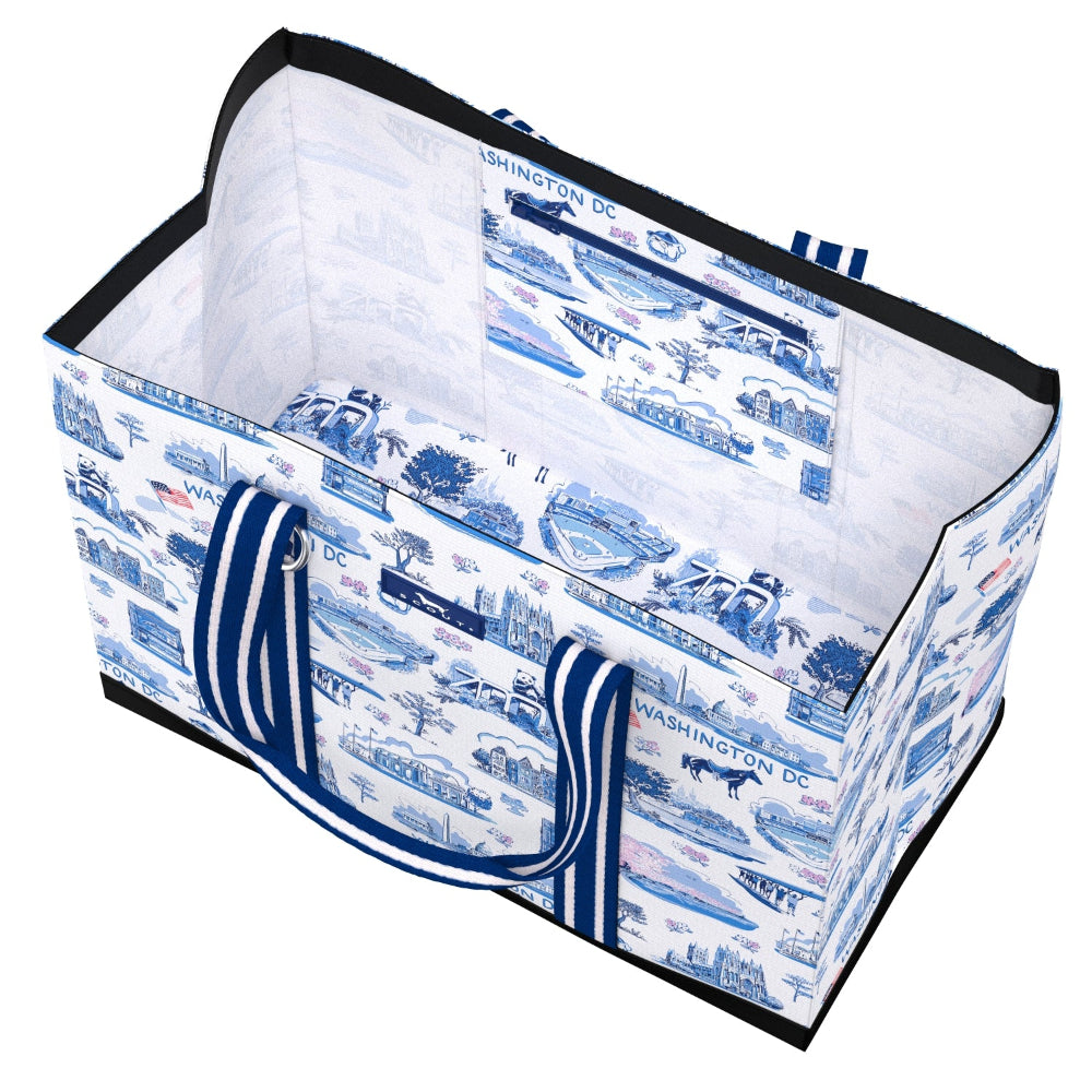 A fabric storage basket with a blue and white toile-style print featuring Washington DC landmarks, complete with blue and white striped handles and black trim.