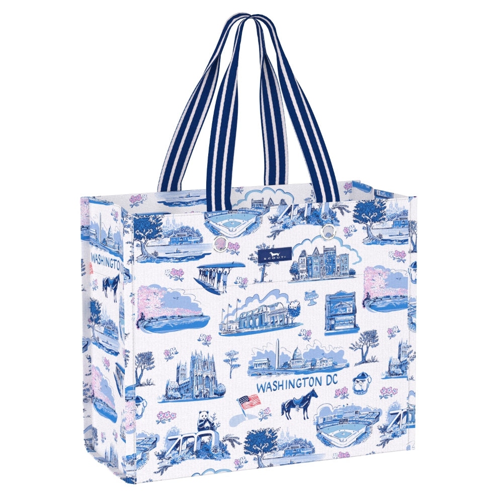 A reusable tote bag with a white background and a blue illustrated pattern of Washington DC landmarks, featuring navy and white striped handles.