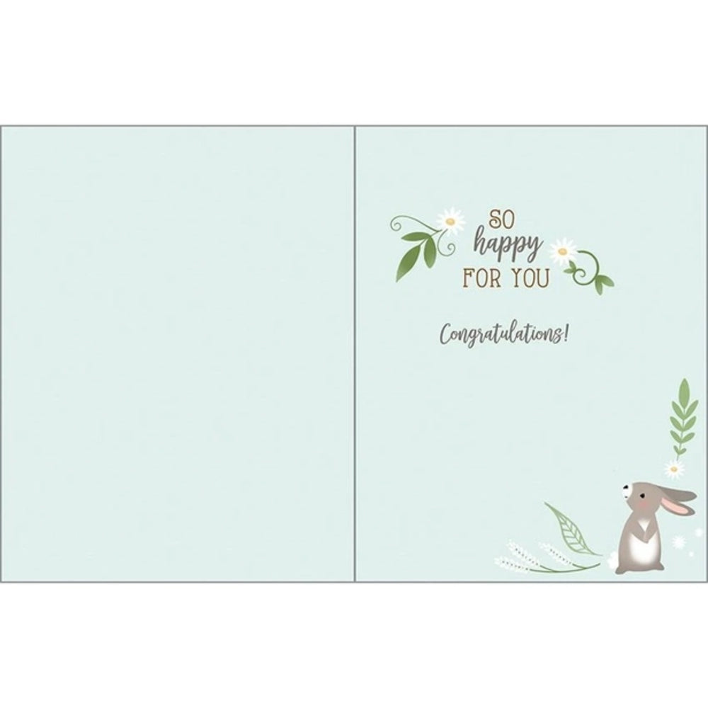 A folded greeting card shown open against a white background. The card has a pale mint green interior with a small bunny illustration, floral accents, and the text 'so happy FOR YOU' and 'Congratulations!' on the right panel.
