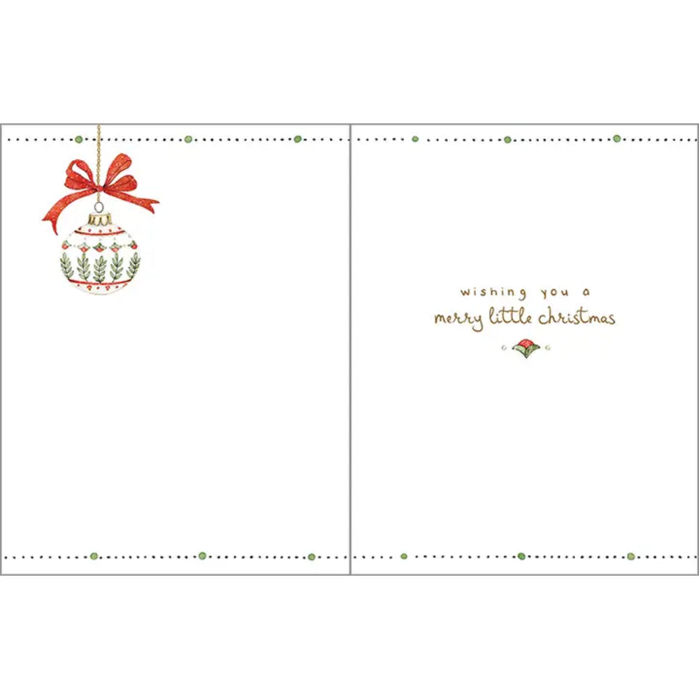 A Christmas greeting card shown open, with a white interior. The left panel features an illustrated red-and-green ornament with a red bow, and the right panel reads 'wishing you a merry little christmas' in brown script with a small ornament motif below.
