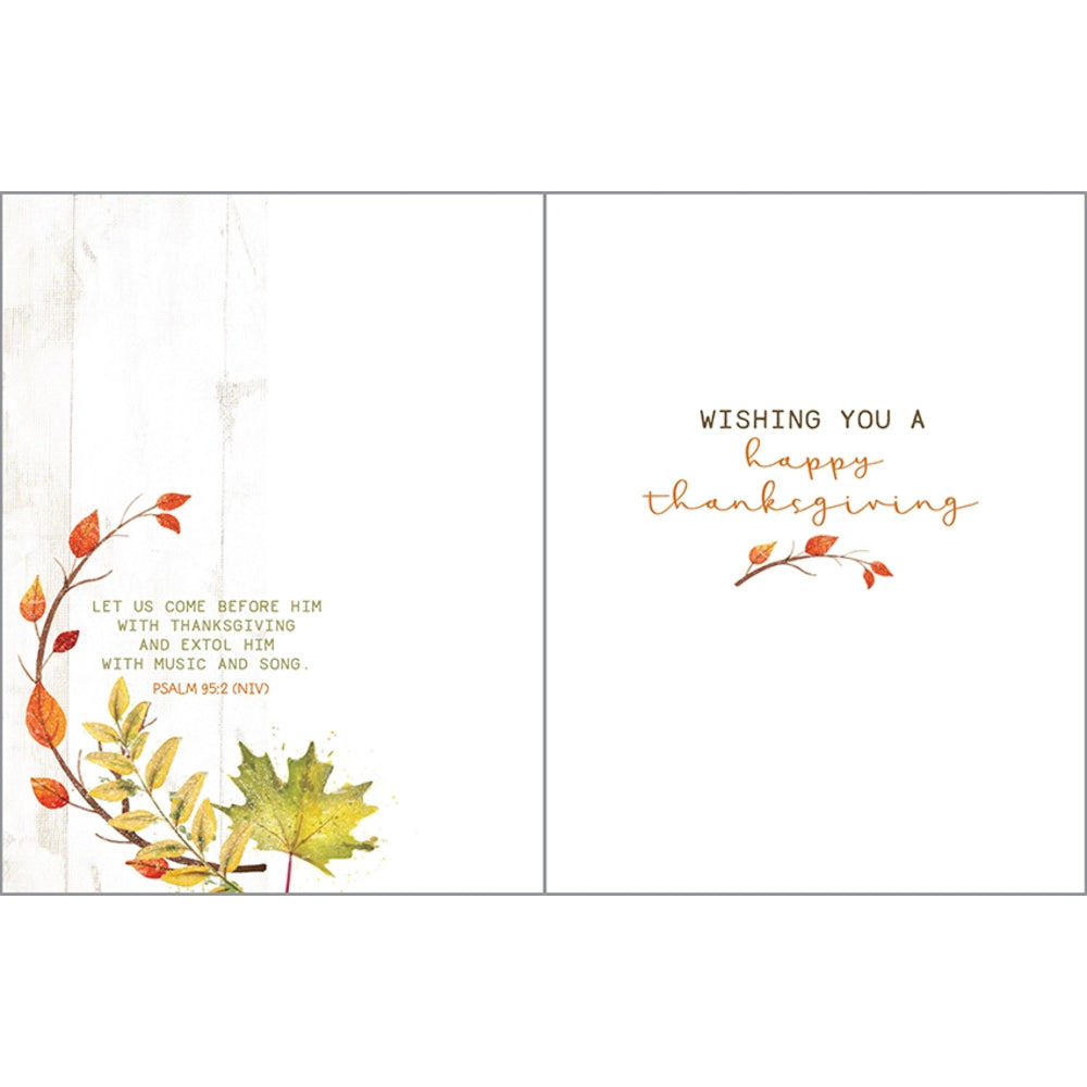 An open greeting card with a white background, autumn leaf watercolor accents in orange, yellow, and red, and Thanksgiving-themed text. The left panel includes a scripture quote and leaf details, while the right panel reads 'WISHING YOU A happy thanksgiving' in black and gold lettering.