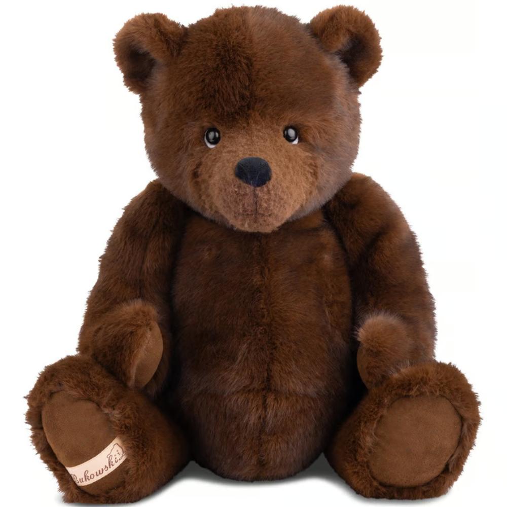Brown teddy bear with a visible brand label on a white background