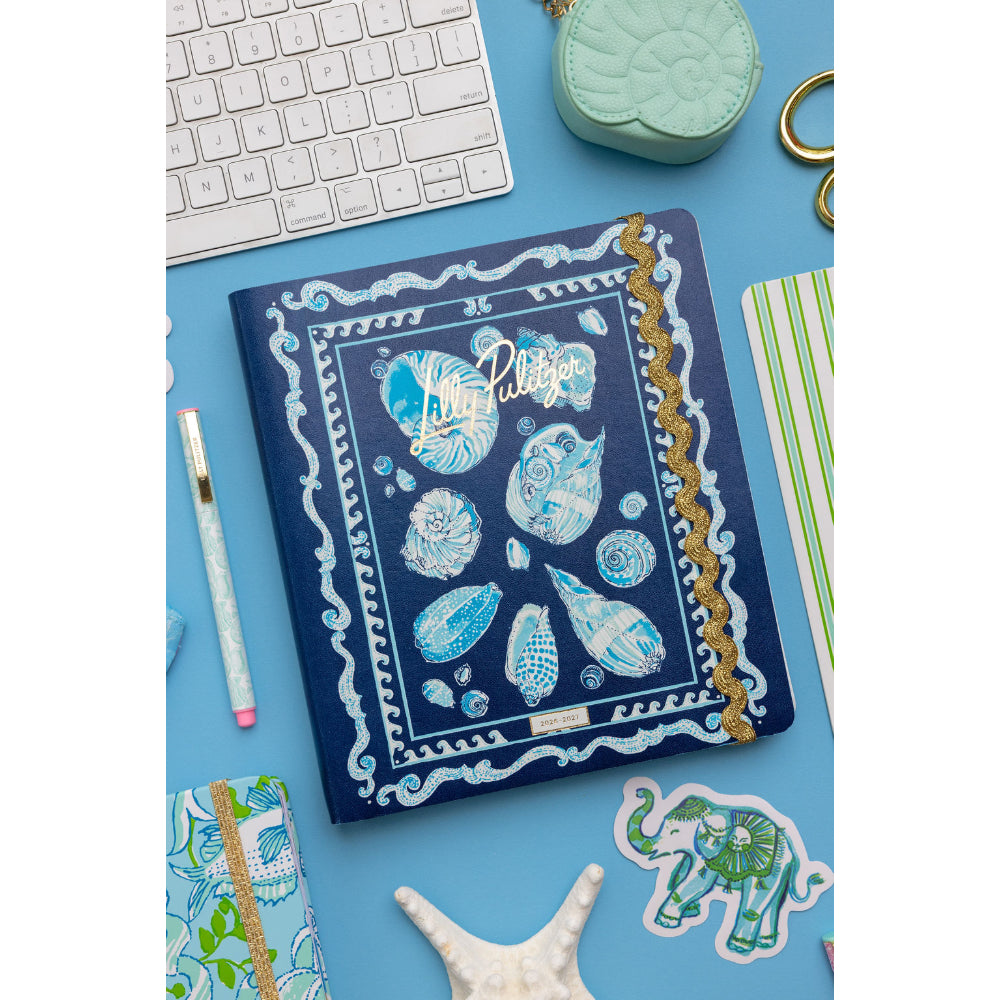 Notebook with blue shell design on a desk with keyboard and stationery items