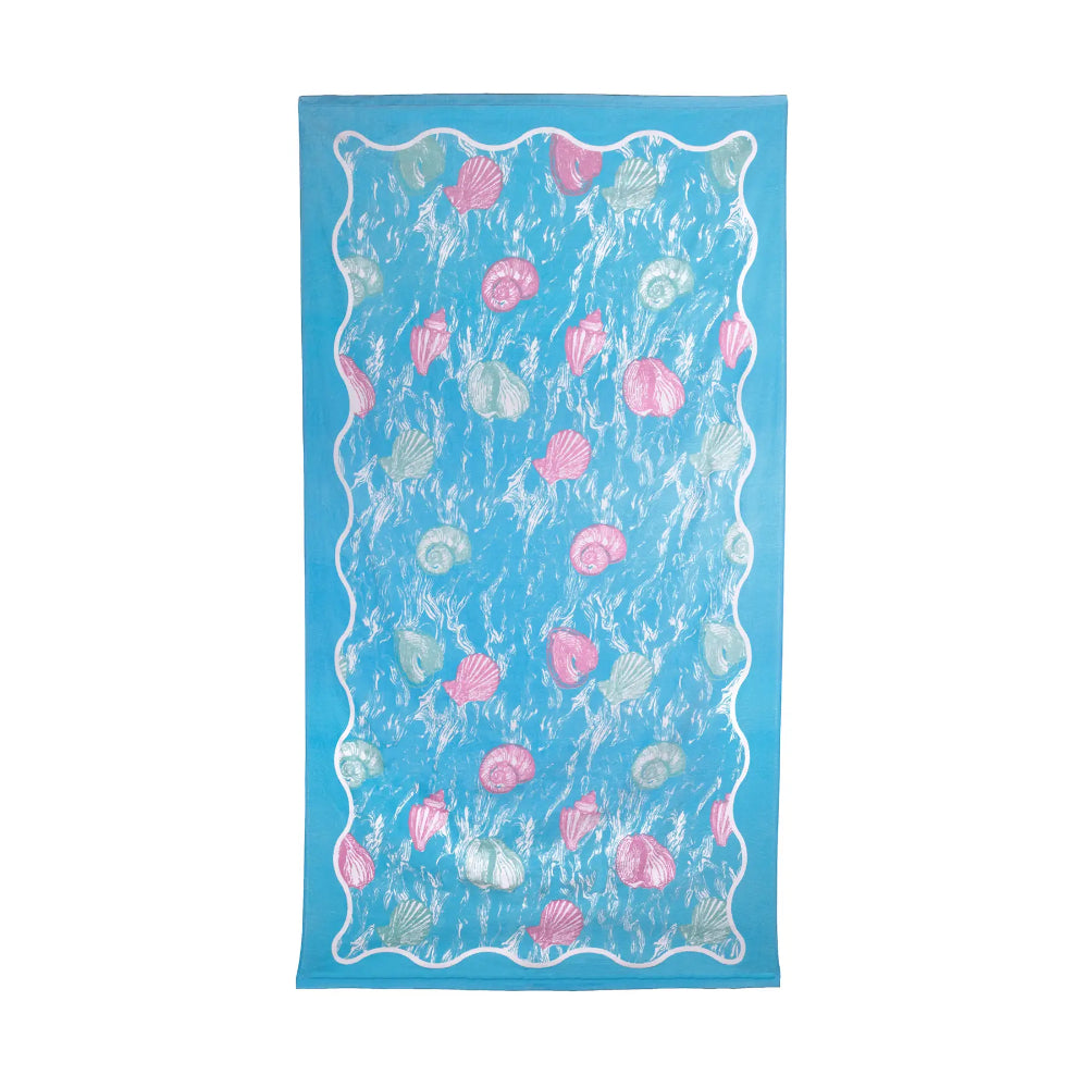 Blue beach towel with colorful pink & white shell pattern on a white background.