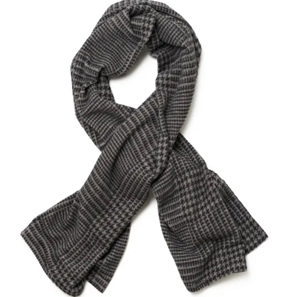 A dark gray and black houndstooth patterned shawl, styled in a loose loop on a plain white background.