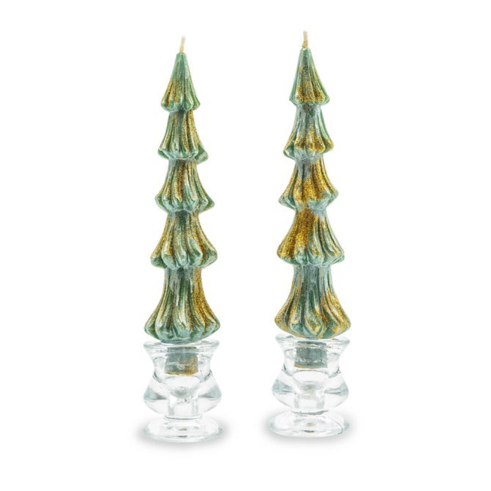 A pair of Christmas tree-shaped taper candles with a textured green and gold finish, set in clear glass holders against a white background.
