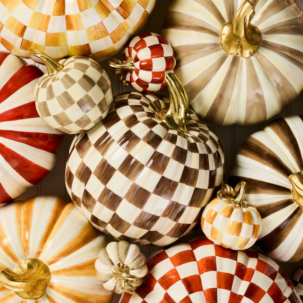 A collection of decorative ceramic pumpkins with various autumn patterns, including stripes, checkerboards, and swirls in brown, cream, orange, and red, with metallic gold stems.