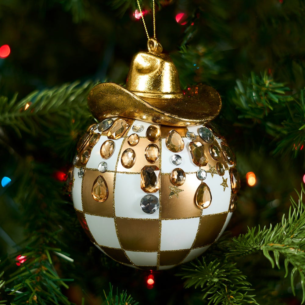Gold check ornament with a gold cowboy hat on top with clear gems on a Christmas Tree.