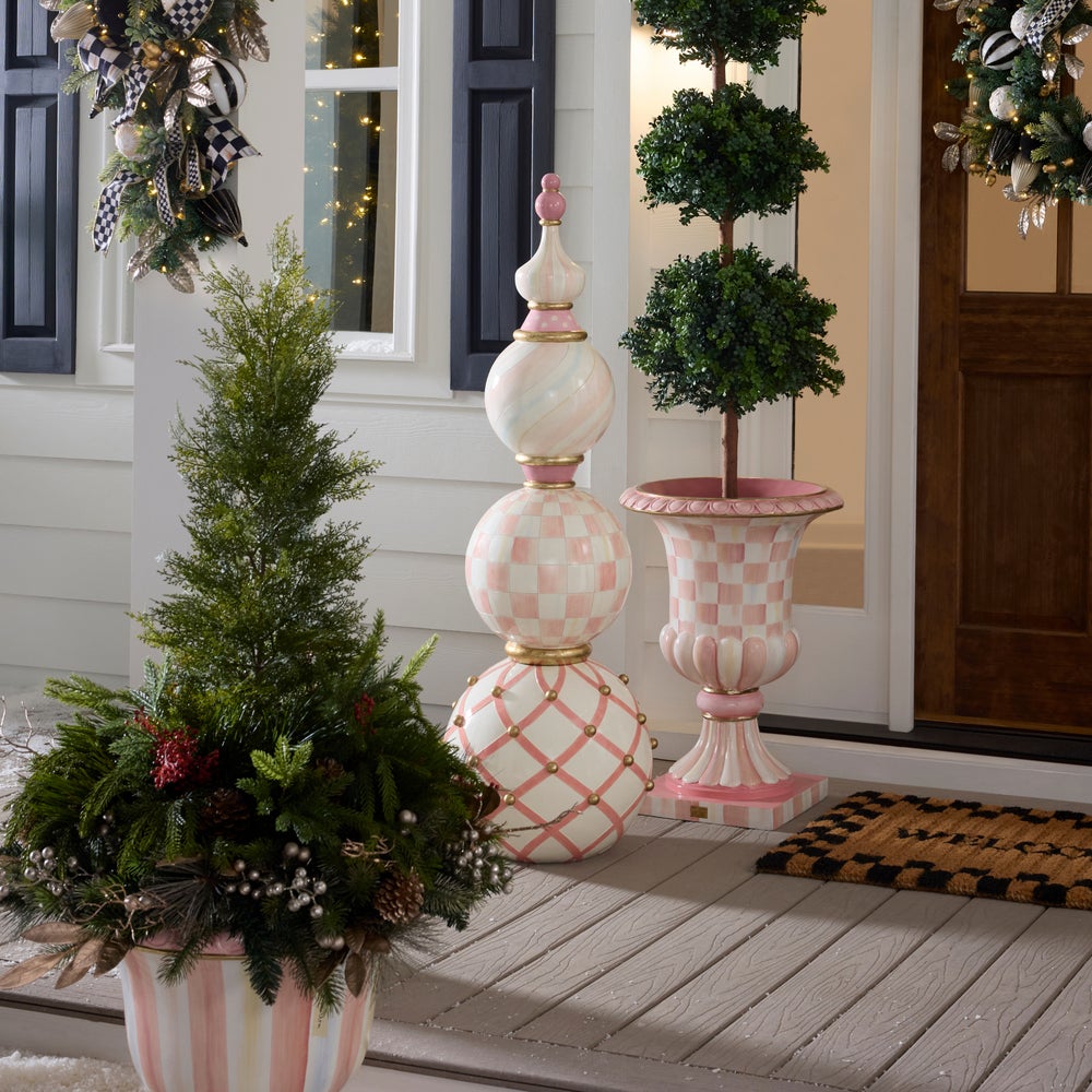 Decorative outdoor setting with potted plants and ornate stands on a porch.