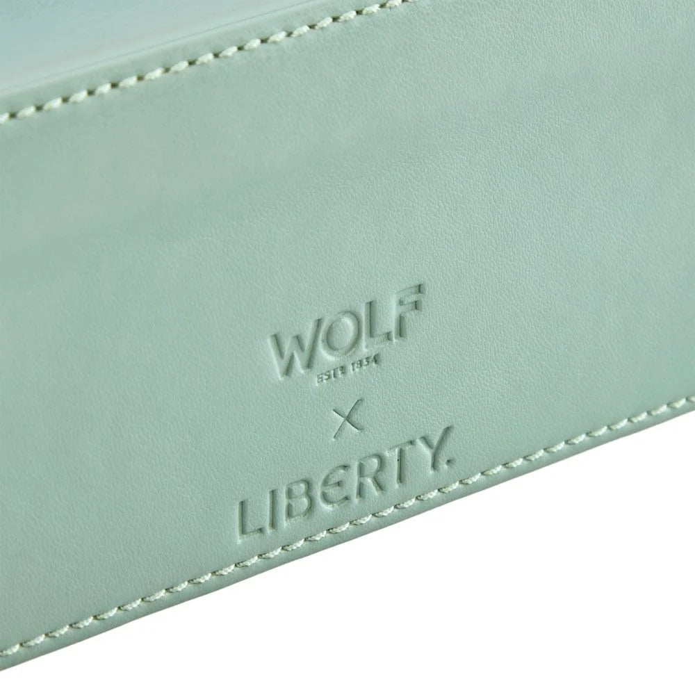 Close-up of a light blue leather product with 'WOLF' and 'LIBERTY' branding.