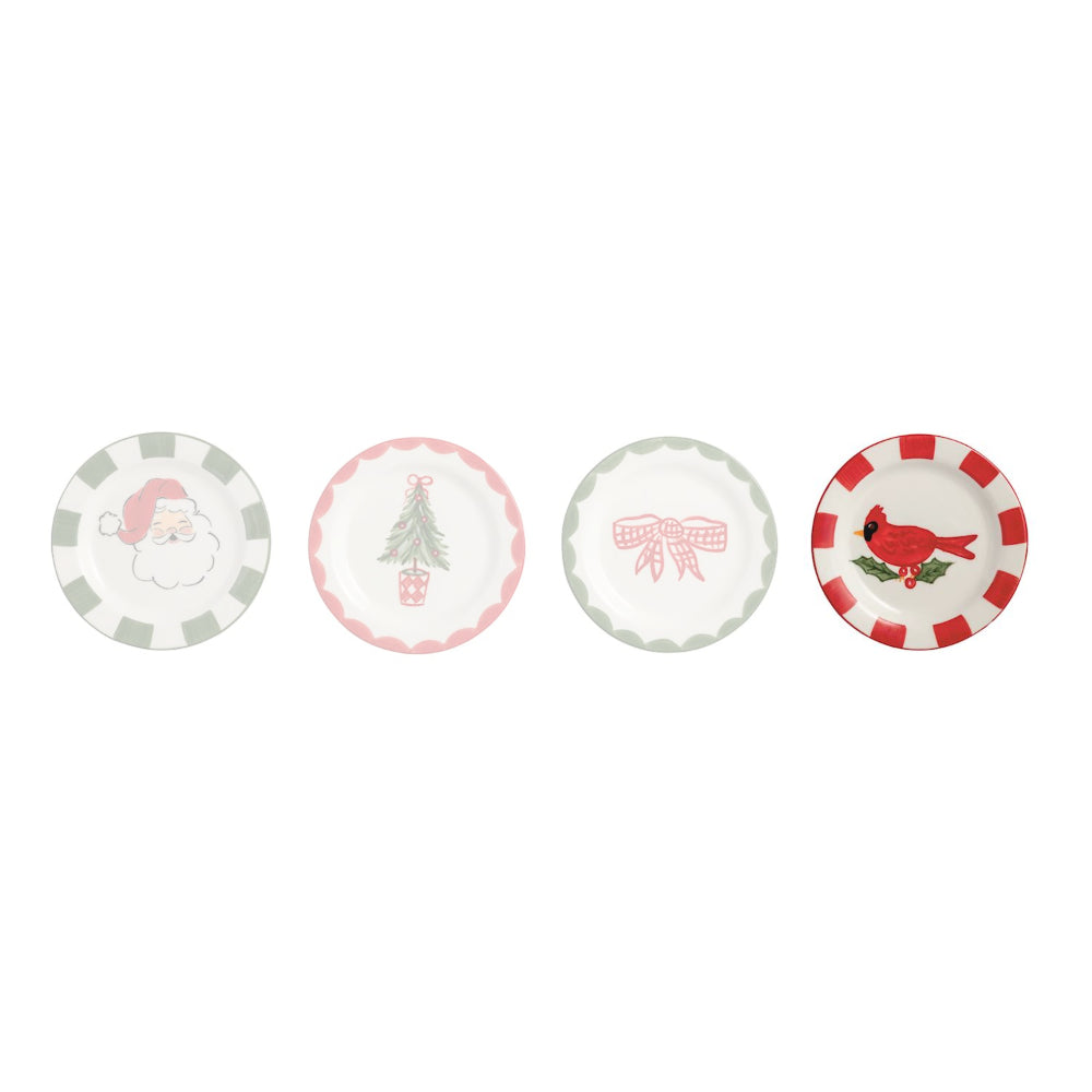 Four small round holiday-themed plates arranged in a row on a white background. The plates feature festive designs including a Santa Claus face, a Christmas tree with a gift box, a pink bow, and a red cardinal on a green branch, with pastel green and pink checkered borders.