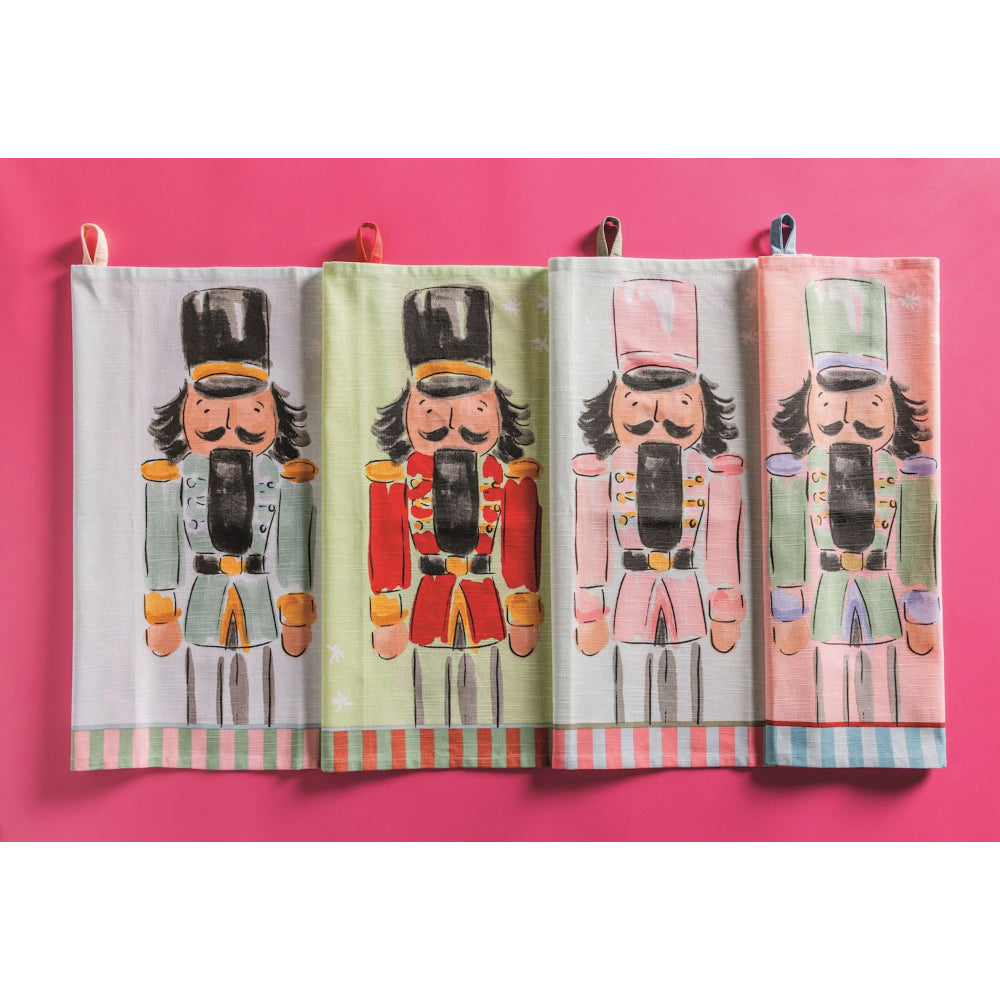 Set of four decorative towels with nutcracker designs on a pink background