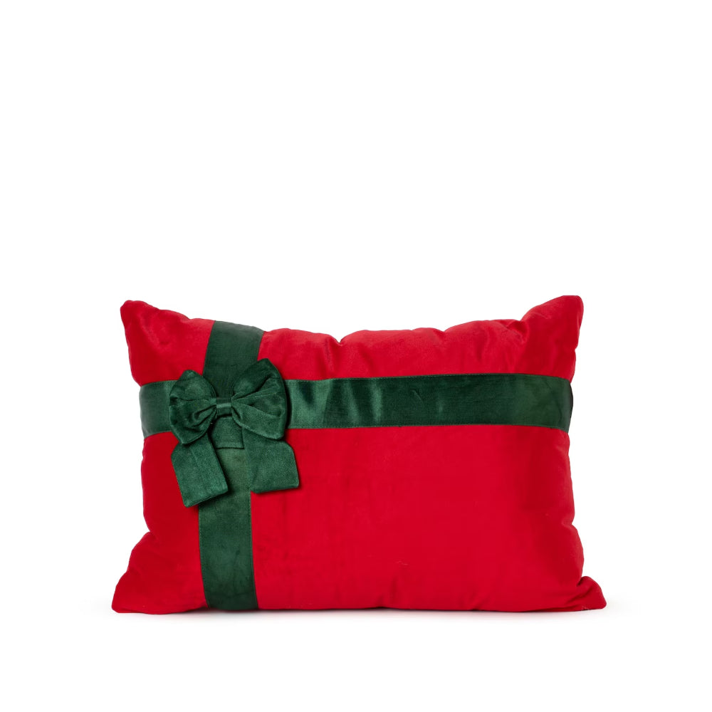A red rectangular throw pillow designed to look like a gift box wrapped with a dark green satin ribbon and bow, shown against a plain white background.
