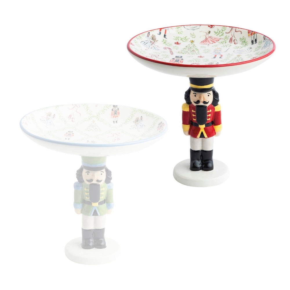 Two decorative nutcracker figurines with circular bases on a white background