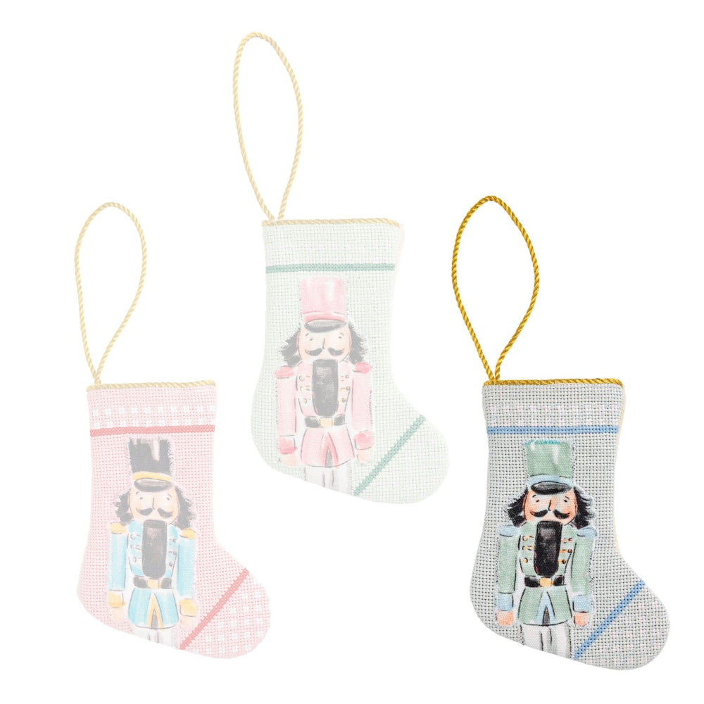 Three decorative Christmas stockings with nutcracker designs on a white background