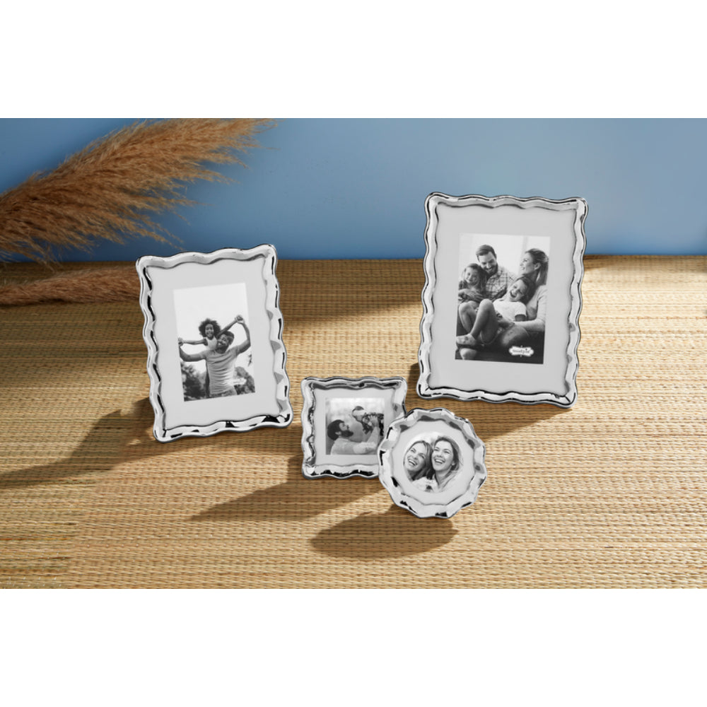 Five differant sized picture frames on a tan backround with a blue wall.