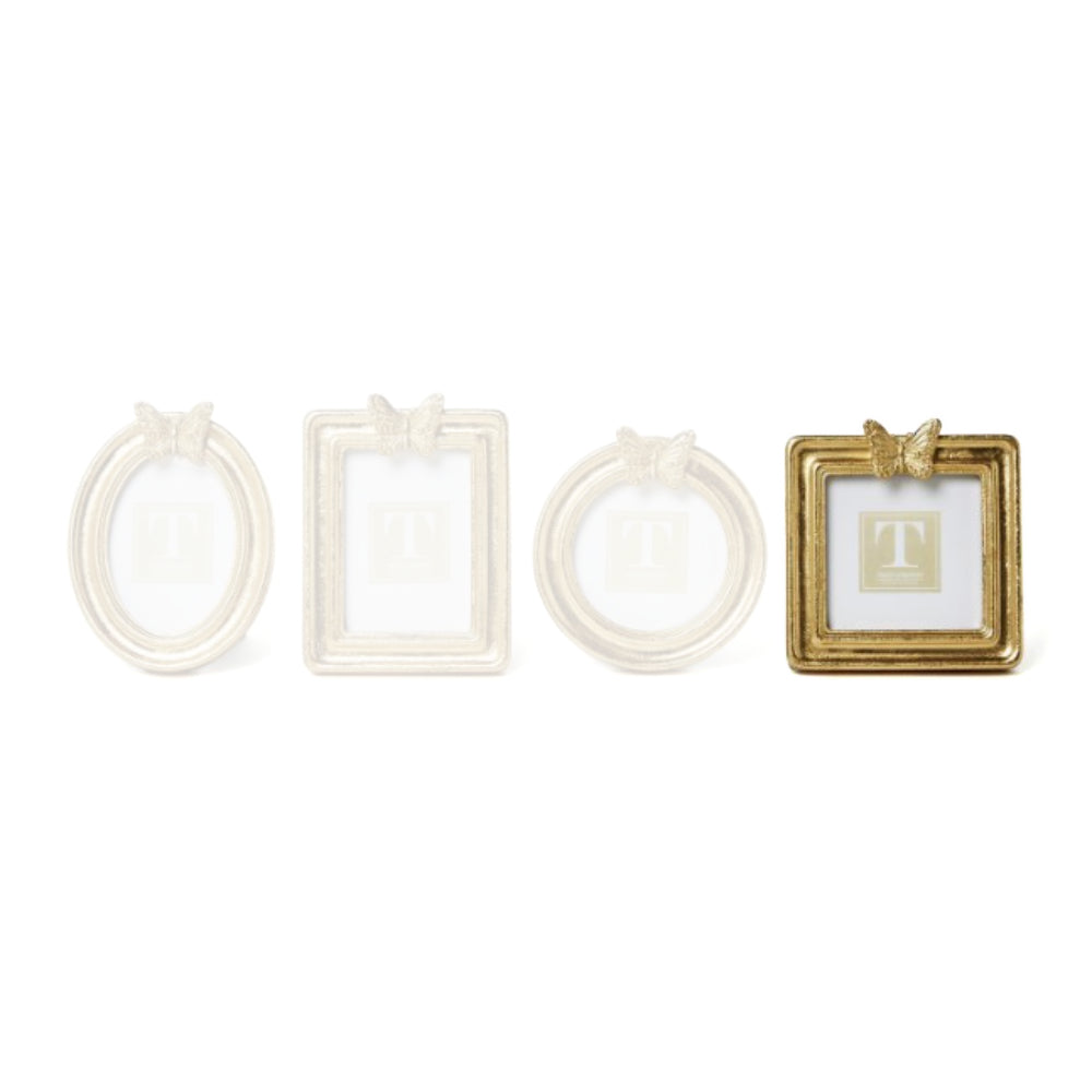 Square gold picture frame with a decorative butterfly on top on a white background.