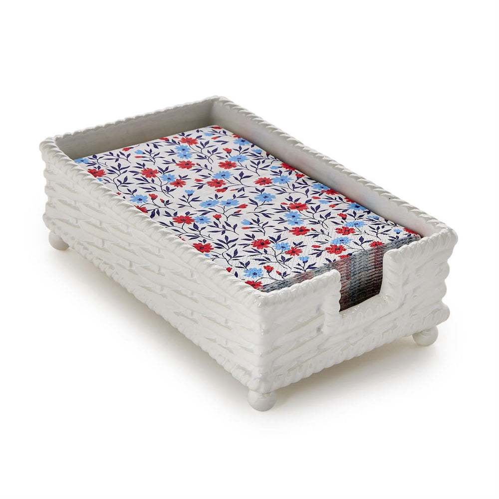 White woven tray with a floral patterned napkin on a white background.