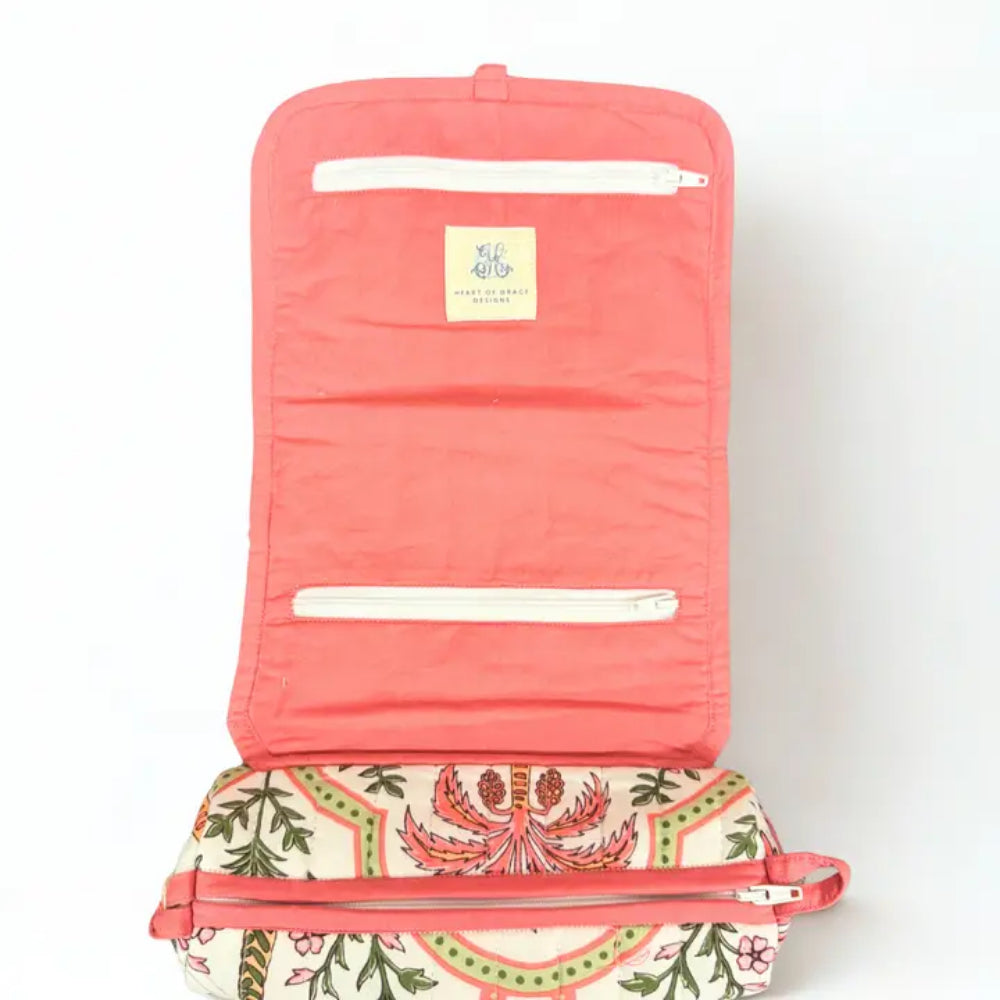 Inside of Jewelery roll with 2 zippers and red/pink background.