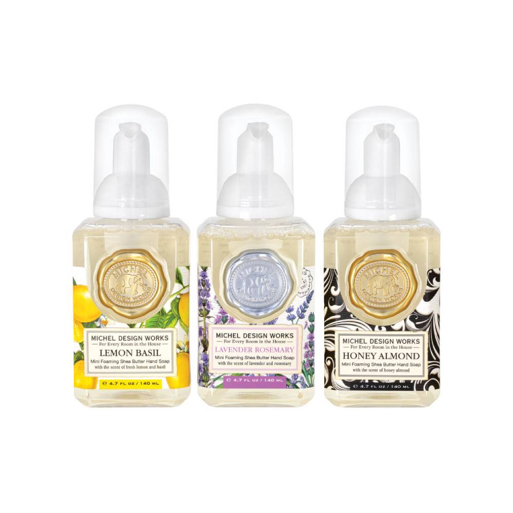 Three colorful bottles of Michel Design Works hand soaps with different scents on a white background.
