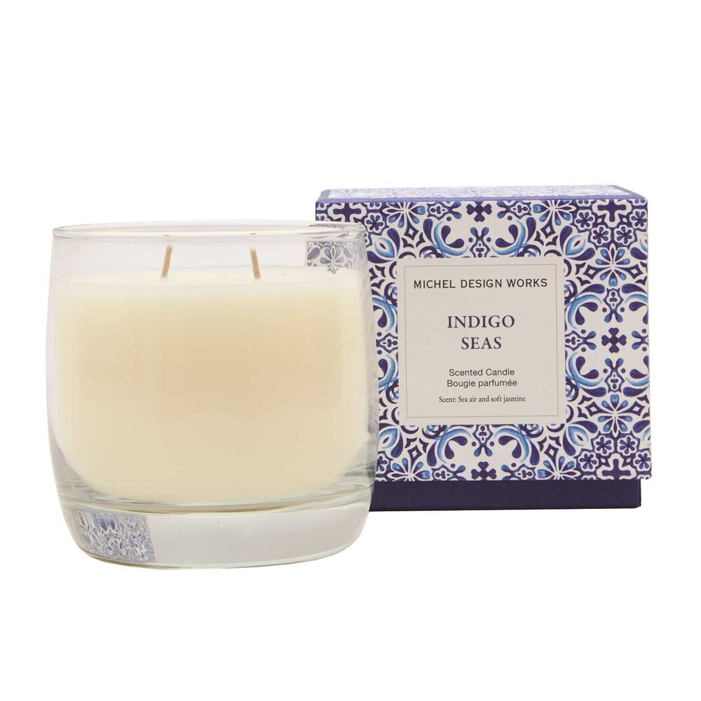 Candle with decorative box labeled 'Indigo Seas' by Michel Design Works on a white background