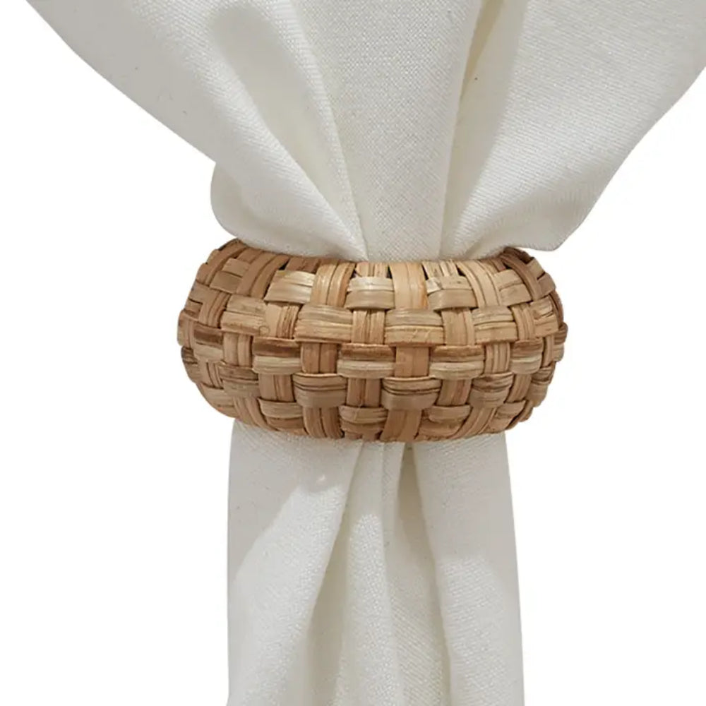 Rattan Woven Napkin Ring around white napkin on white background.