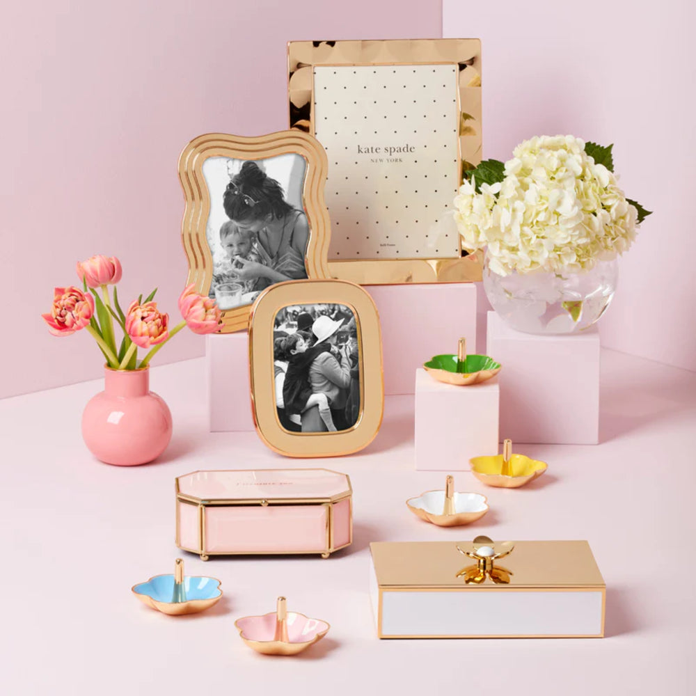 Kate Spade South Street Gold 8x10 Scallop Photo Frame with other gold frames and gold colored decor with a blue, yellow, pink, green & white ring dishes on a pink backround.