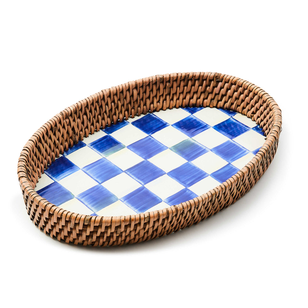 Small oval-shaped tray with wicker rim and royal blue and white checkered surface on a white background