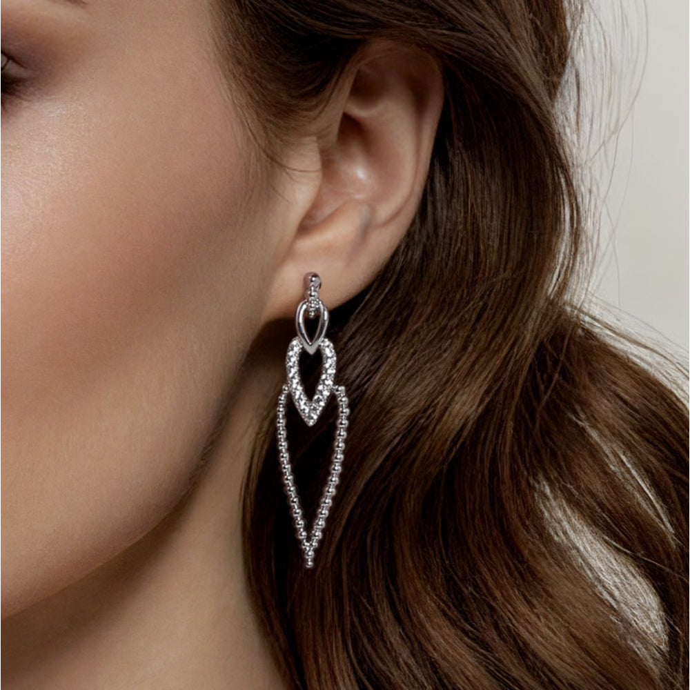 Close-up of a woman wearing a silver earring with a blurred background