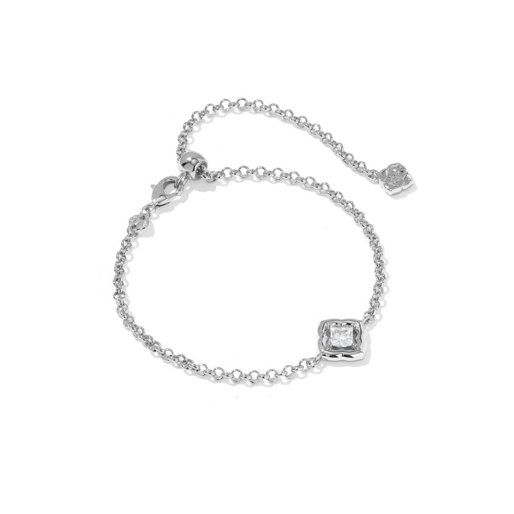 A delicate silver chain bracelet with a square bezel-set clear gemstone and an adjustable extender chain with a small heart charm, shown on a plain white background.