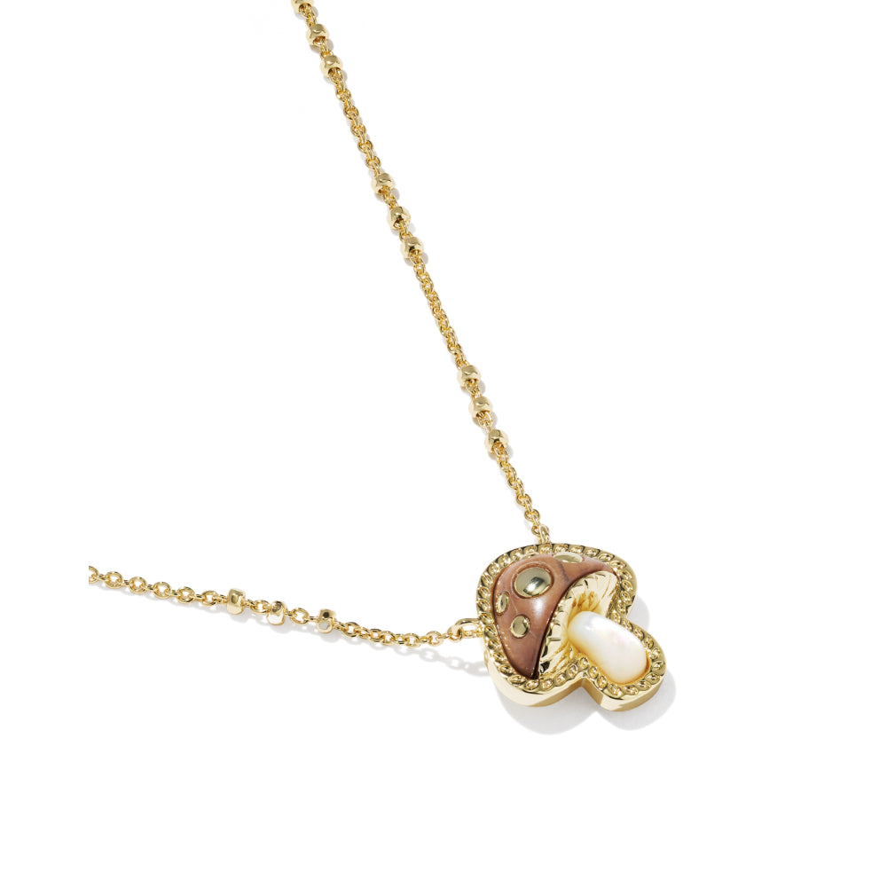 A gold necklace with a mushroom-shaped pendant featuring a pinkish-brown cap, a white pearl center, and small clear stones, shown on a white background.