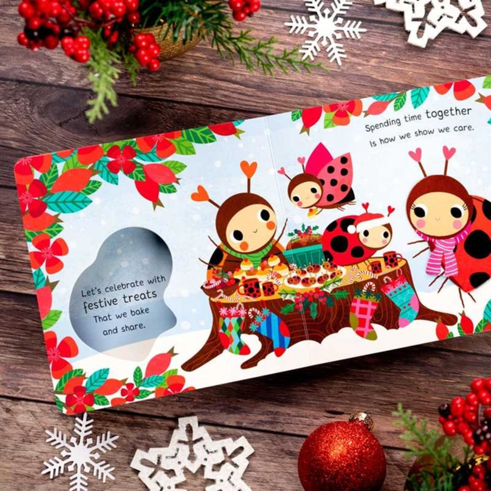 Children's book with Christmas-themed illustrations on a wooden surface with festive decorations.