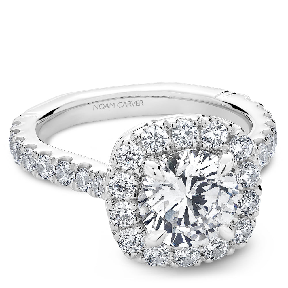 Diamond halo ring with 'Noam Carver' branding on a white background