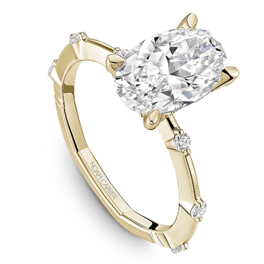 Gold Noam Carver ring with an oval diamond center and round diamond shank accents on a white background